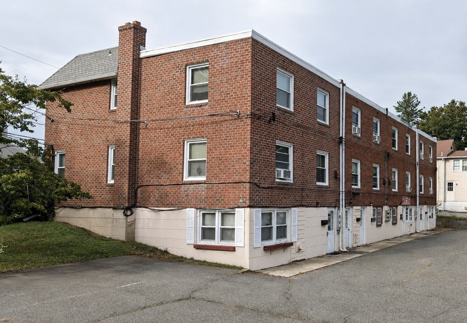 Exterior of the JHL Pergolas office in Newtown Square, PA — a three-story red-brick building with white-trimmed windows and a brick chimney, at 12 Smedley Lane.